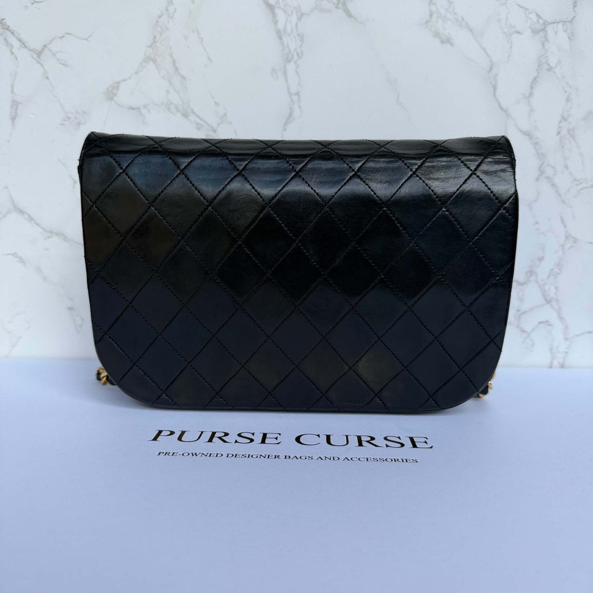Achterkant authentieke Chanel tas double half moon flap zwart lamsleer