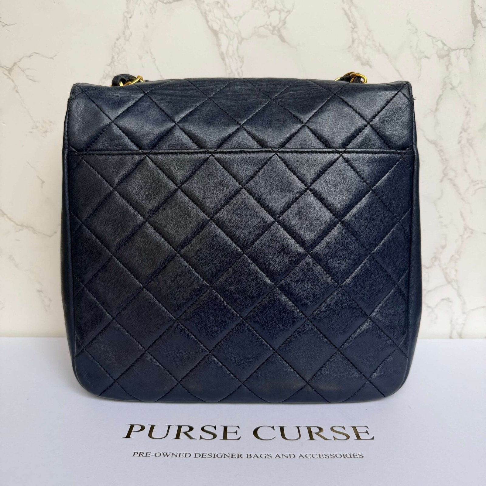 Backside of pre-loved Chanel single flap crossbody in blue lambskin