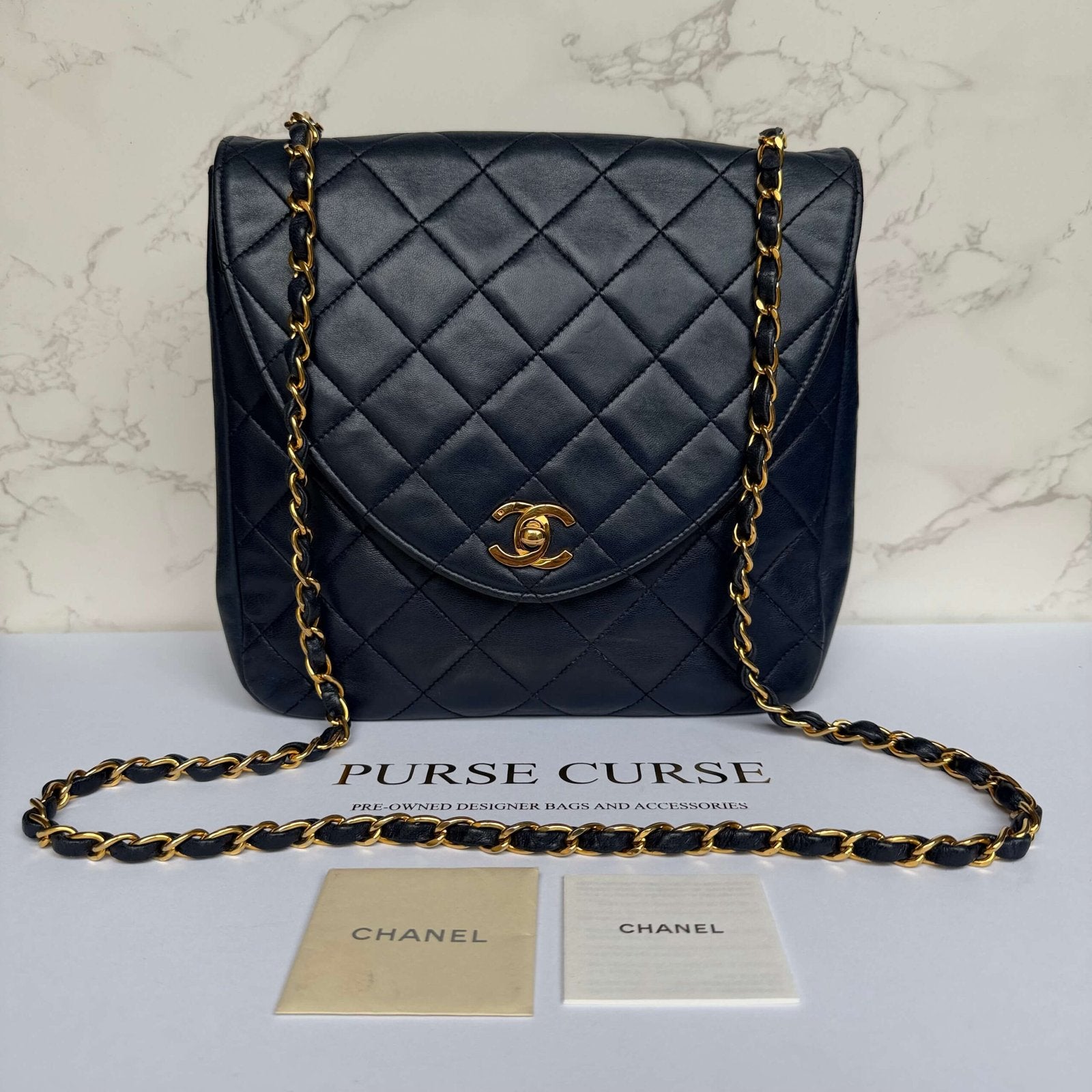 Second-hand authentic Chanel vintage crossbody flap bag in navy lambskin with Chanel booklet