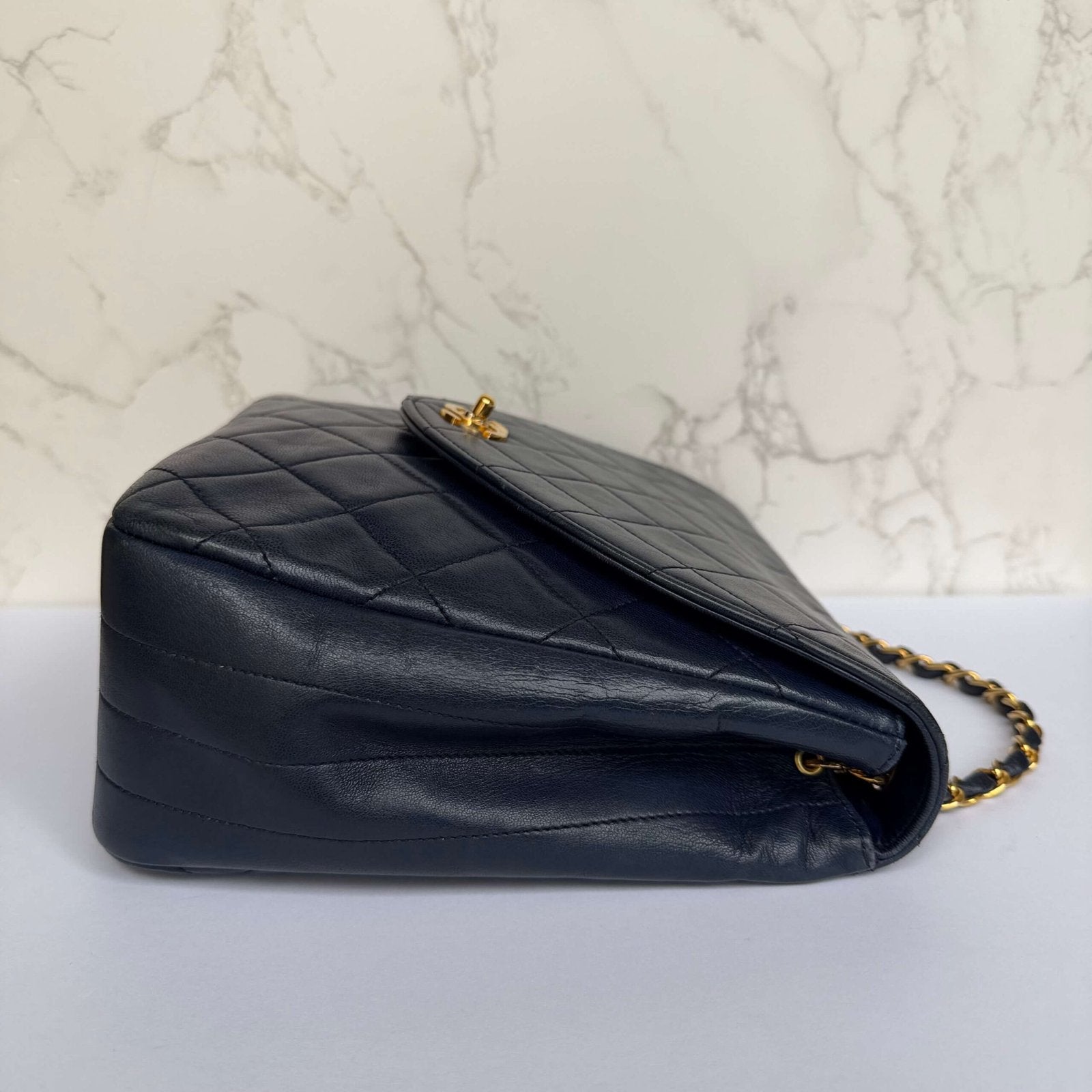 Side view of original Chanel single flap bag in dark navy lambskin