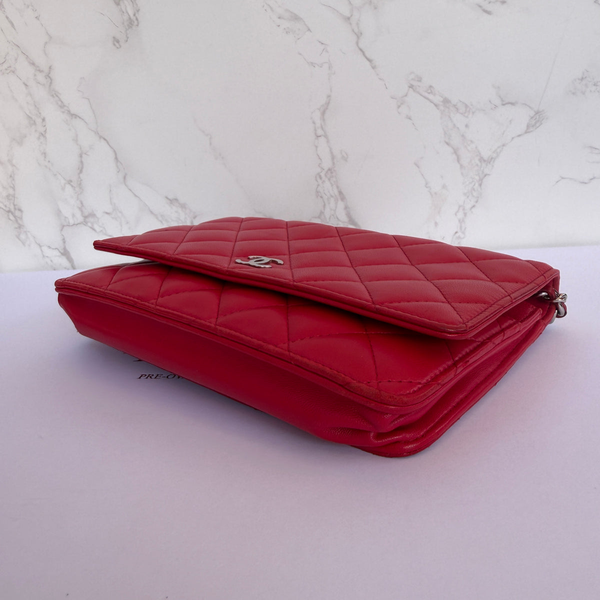 Zijkant Chanel wallet on chain rood lamsleer hoekjes tweedehands